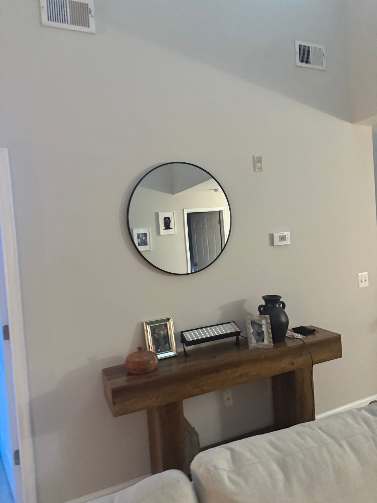 Round mirror and wooden console styled in Erica's home
