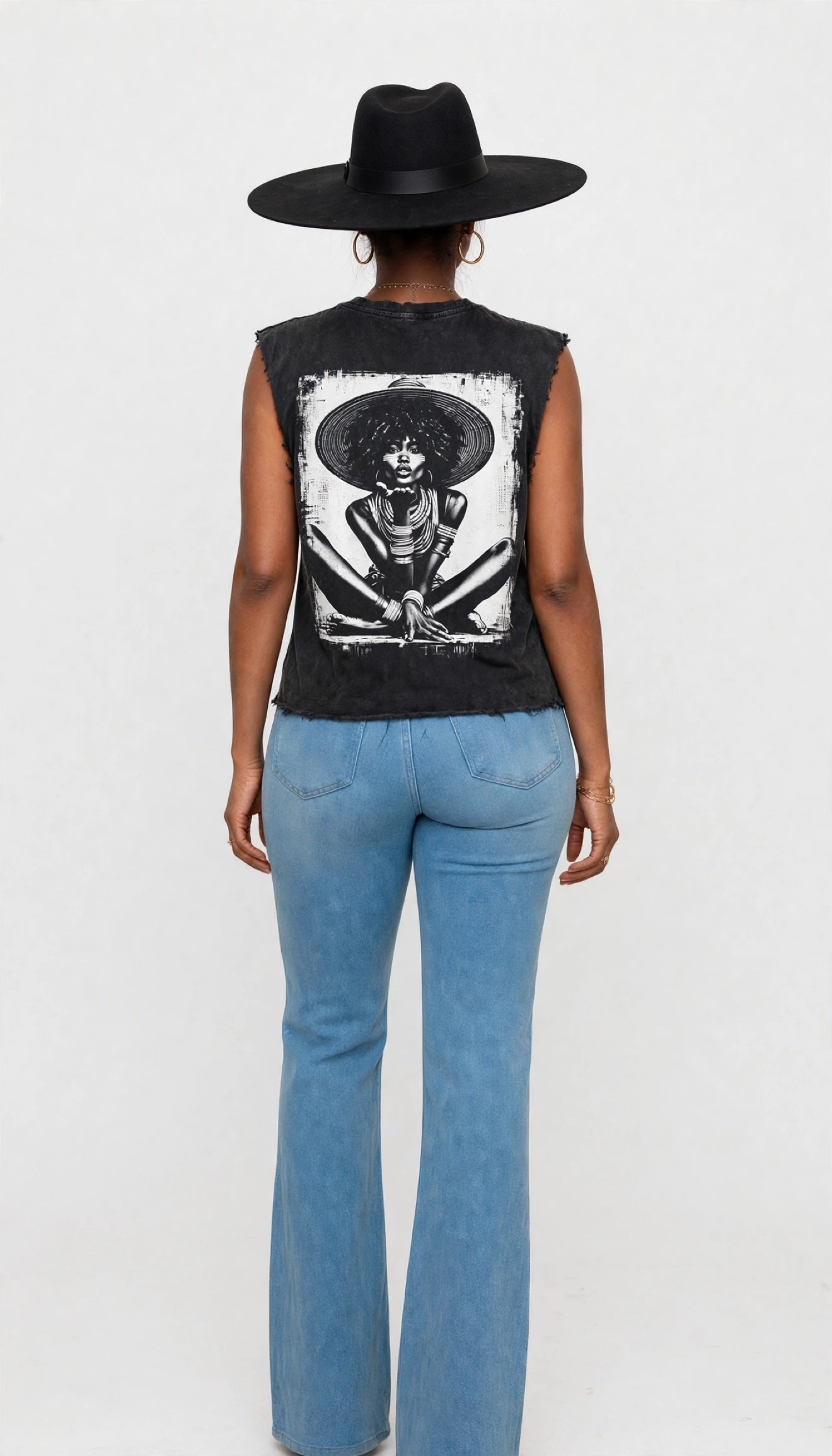 Back view of Erica modeling the black sleeveless cutoff tee with a large face-paint kiss graphic
